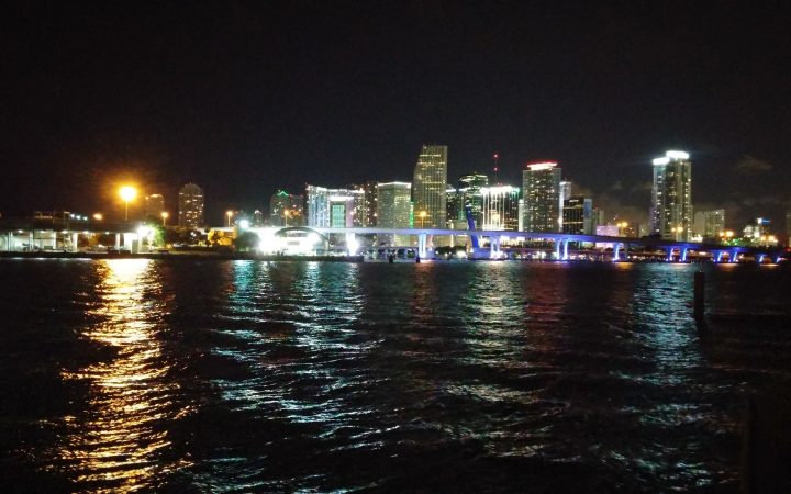 Downtown Miami skyline lit up at night over Biscayne Bay